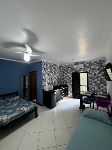 een slaapkamer met een bed, een bureau en een tafel bij Flats e Apartamentos Temporada Mar Brasil in Ubatuba