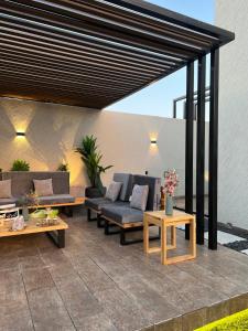 a patio with couches and tables on a patio at شاليهات نافارو in Ghurābah