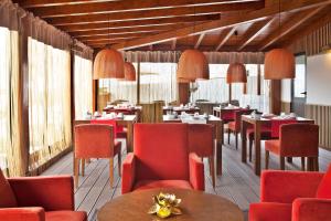 a restaurant with red chairs and tables and windows at Sao Rafael Holidays in Albufeira