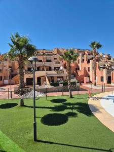 a street light in a park with palm trees and buildings at S&H La Consentida in San Juan de los Terreros