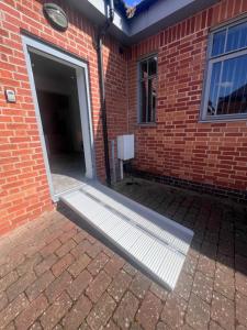 Una puerta que conduce a un edificio de ladrillo con una ventana. en Syster Properties Comfortable Leicester Glen Cottage Stay with Free Parking LE3, en Leicester