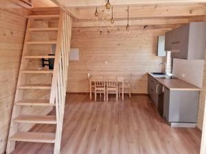 a kitchen and dining room with a ladder in a tiny house at Domek Leon in Okuninka