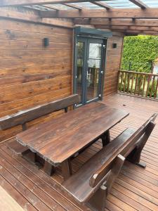 a wooden bench sitting on a wooden deck at Domek Leon in Okuninka