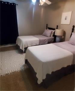 a room with two beds and a lamp at Charming 4-BR Home for Rent! in Spring