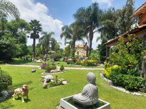 a buddha statue and a dog in a garden at Campamento Hermoso en la naturaleza in Chapulco