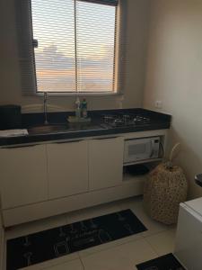 a kitchen with a sink and a microwave at Chalé Gameleiras in Monte das Gameleiras +14 photos