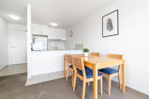 kuchnia i jadalnia z drewnianym stołem i krzesłami w obiekcie Relaxing 2BR Apt in North Point Complex - Hosted by Canstay w mieście Weston Creek