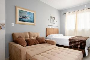 un salon avec un canapé et un lit dans l'établissement Studio 3 - Linda vista beira-mar, à Florianópolis