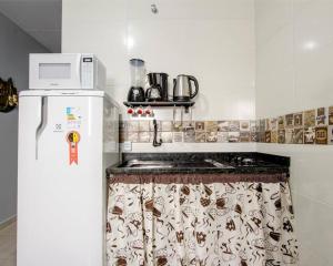 une cuisine avec une cuisinière et un micro-ondes dans l'établissement Studio 3 - Linda vista beira-mar, à Florianópolis 13 autres photos