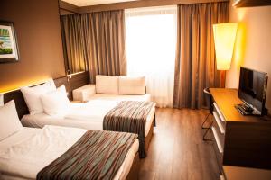 a hotel room with two beds and a television at Expo Hotel in Prague