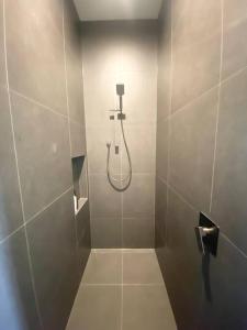 a shower stall with a hose in a bathroom at Luxe Loft - Inner City - Napier in Napier