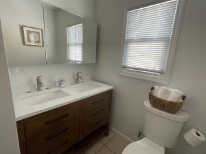 a bathroom with a sink and a toilet and a mirror at Villetta Solare in Belmar