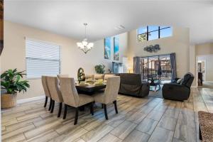 a dining room and living room with a table and chairs at Experience Solterra: Pool, Spa, Game Room & Lazy River in Davenport