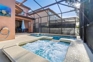 a hot tub in the backyard of a house at Experience Solterra: Pool, Spa, Game Room & Lazy River in Davenport