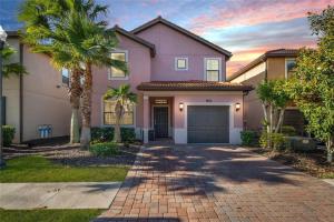 a house with palm trees in front of a driveway at Experience Solterra: Pool, Spa, Game Room & Lazy River in Davenport