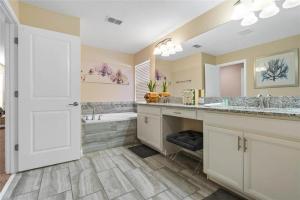 a bathroom with two sinks and a tub at Experience Solterra: Pool, Spa, Game Room & Lazy River in Davenport