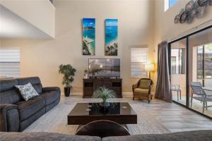 a living room with a couch and a tv at Experience Solterra: Pool, Spa, Game Room & Lazy River in Davenport