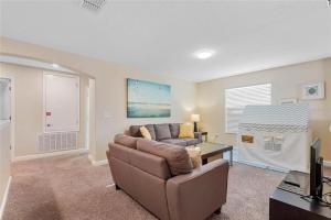 a living room with a couch and a table at Experience Solterra: Pool, Spa, Game Room & Lazy River in Davenport