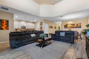 a living room with two couches and a kitchen at Experience Solterra: Pool, Spa, Game Room & Lazy River in Davenport