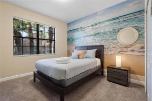 a bedroom with a bed and a painting of the ocean at Experience Solterra: Pool, Spa, Game Room & Lazy River in Davenport