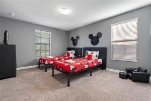 a bedroom with two beds with red comforter at Experience Solterra: Pool, Spa, Game Room & Lazy River in Davenport
