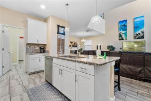 a kitchen with white cabinets and a counter top at Experience Solterra: Pool, Spa, Game Room & Lazy River in Davenport