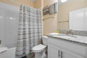 a bathroom with a toilet and a sink and a shower at Experience Solterra: Pool, Spa, Game Room & Lazy River in Davenport