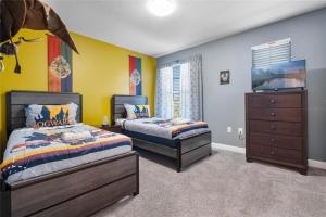 a bedroom with two beds and a dresser at Experience Solterra: Pool, Spa, Game Room & Lazy River in Davenport +33 photos