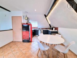 a kitchen with a white table and chairs and a refrigerator at Appartement mansardé rénové à Rambouillet, 2 chambres, tout inclus, proche château et gare. - FR-1-527-47 in Rambouillet