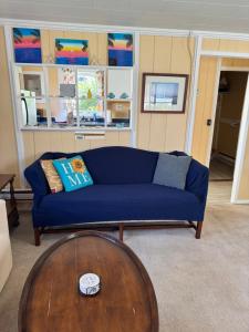 a living room with a blue couch and a wooden table at Beach Cottage on North Beach in Hampton