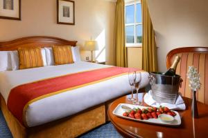 a hotel room with a bed and a tray of fruit at Killarney Plaza Hotel & Spa in Killarney