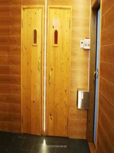 a wooden wall with two wooden doors in a room at Homestay 8 phòng ngủ Bể bơi riêng- Hà Nội in Ba Vì