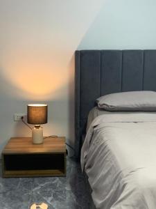 a bedroom with a bed and a table with a lamp at Zagill Moalboal in Moalboal