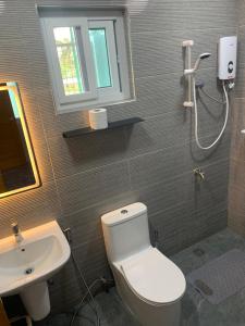 a bathroom with a white toilet and a sink at Zagill Moalboal in Moalboal +18 photos