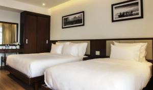 Giường trong phòng chung tại Di lusso Boutique Hotel Riverside Danang