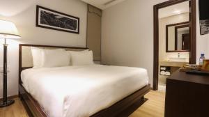 Giường trong phòng chung tại Di lusso Boutique Hotel Riverside Danang