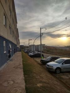 una fila di auto parcheggiate accanto a un edificio di apartamento no paraiso a Ponte Nova