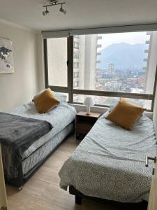 Una cama o camas en una habitación de Departamento en Las Condes Premium Parque Arauco con Aire Acondicionado