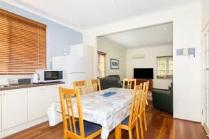 una cucina e una sala da pranzo con tavolo e sedie di Park Rise Cottage a Busselton