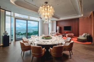 a dining room with a table and chairs and a chandelier at MGM Shenzhen in Shenzhen