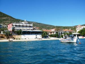 ein Boot, das im Wasser neben einem Strand liegt in der Unterkunft Blue Sky Studios in Xiropigado