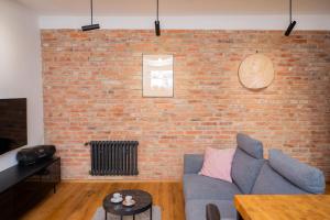 a living room with a brick wall and a couch at Zlinapartman in Zlín