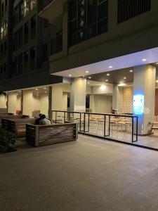 a person sitting on a bench in front of a building at Apartemen trans cibubur BY SANTUY ROOM in Kalimanggis +8 photos