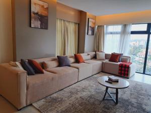a living room with a large couch and a table at Contemporary apartment at Lemac in Nairobi