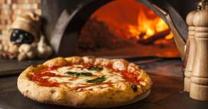 a pizza sitting in front of a pizza oven at B&B da Maria & Renato il Lago Trattoria in Mirabella Eclano