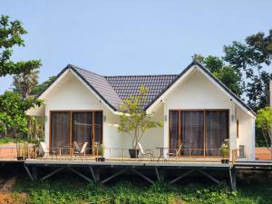 达叻府The Duck Cafe and Resort的房屋设有大甲板和椅子