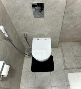 a bathroom with a white toilet in a stall at Cozy Apartment in Boshar in Muscat