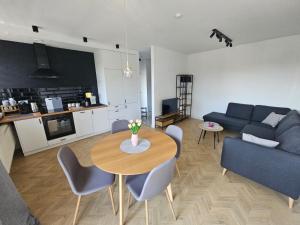 una sala de estar con una mesa y un sofá en TG Loft Apartments, en Tarnowskie Góry