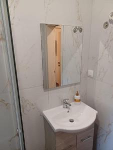 a white bathroom with a sink and a mirror at fotinoula1975 in Ágios Rókkos +36 photos