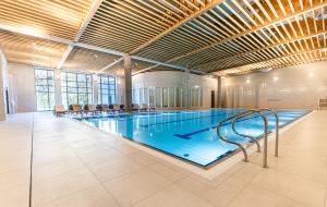 a large swimming pool in a large building at Instytut Zdrowia Sofra FIT & SPA in Mielno